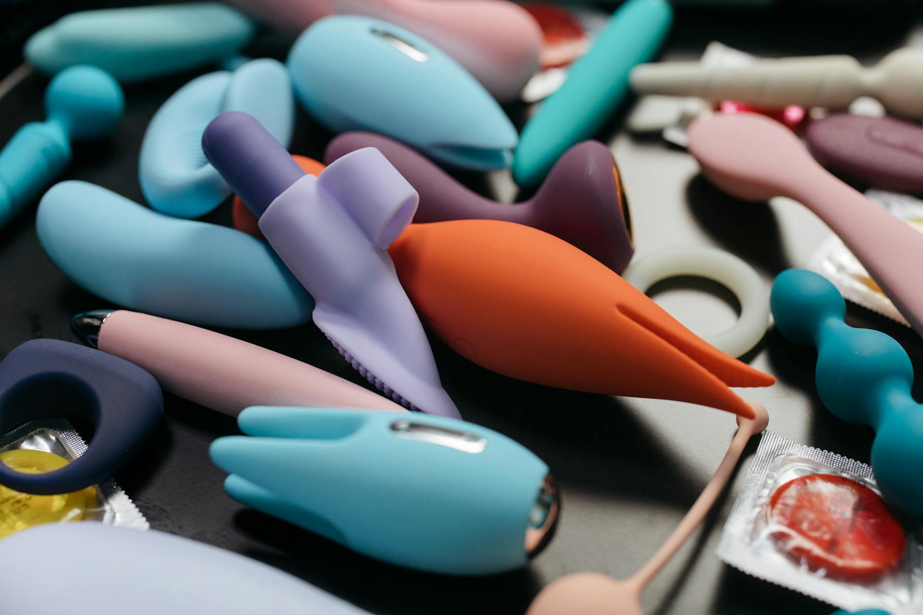 Woman with glasses holding a pink vibrator with art books in soft background light