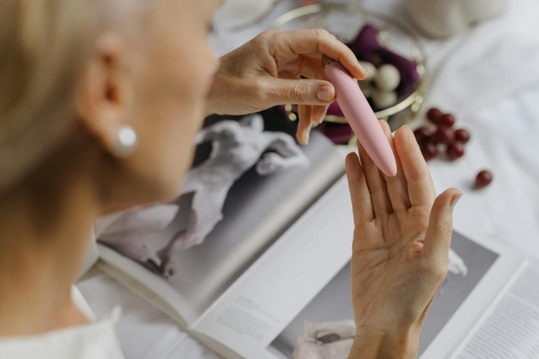 Woman holding blue and pink silicone vibrators, exploring options for restoring clitoral sensation